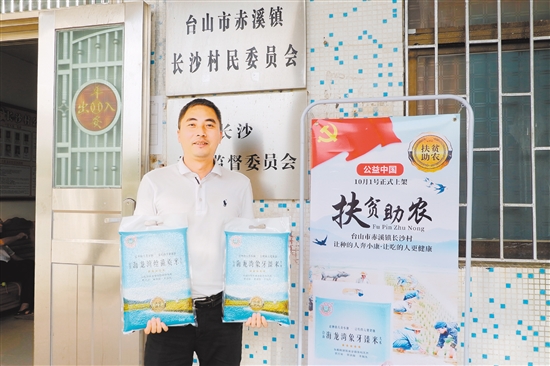 李荣俊向大家展示赤溪镇长沙村打造的“海龙湾”品牌台山大米。