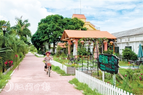 唐丰民宿坐落在绿树红花丛中。