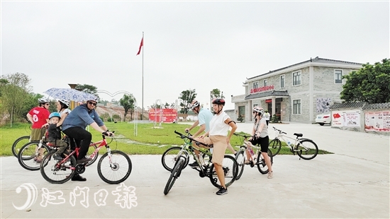 游客骑行游开平乡村，享受美丽的田园风光。